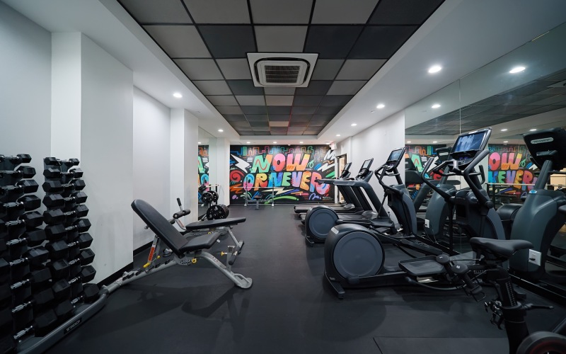 Gym with fitness machines and a bright inspirational mural.